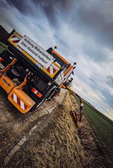 Straßenbegleitgrün Mäharbeiten mit Unimog und Auslegermähgerät